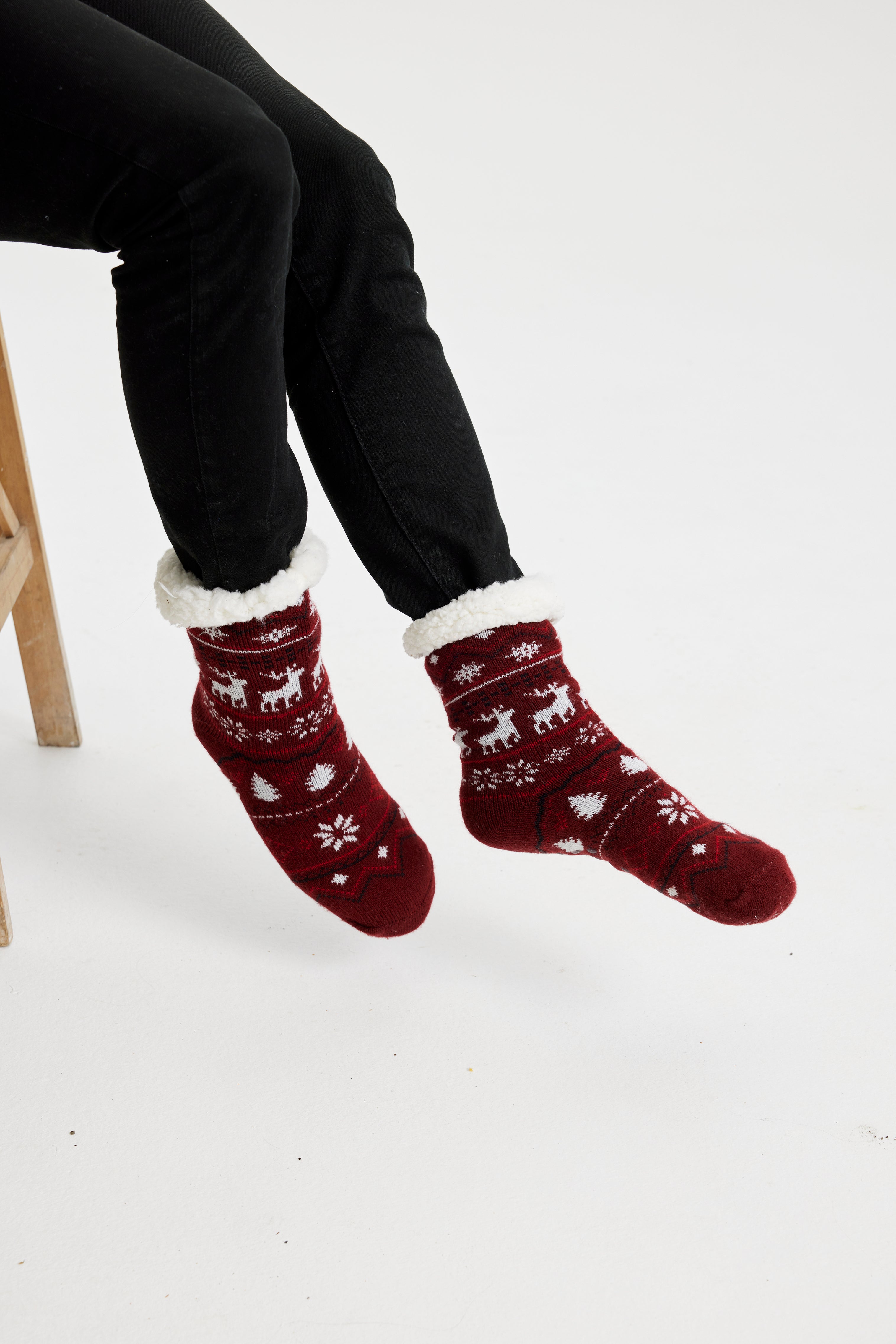 Gambe con calzini natalizi rosso scuro con fantasia.