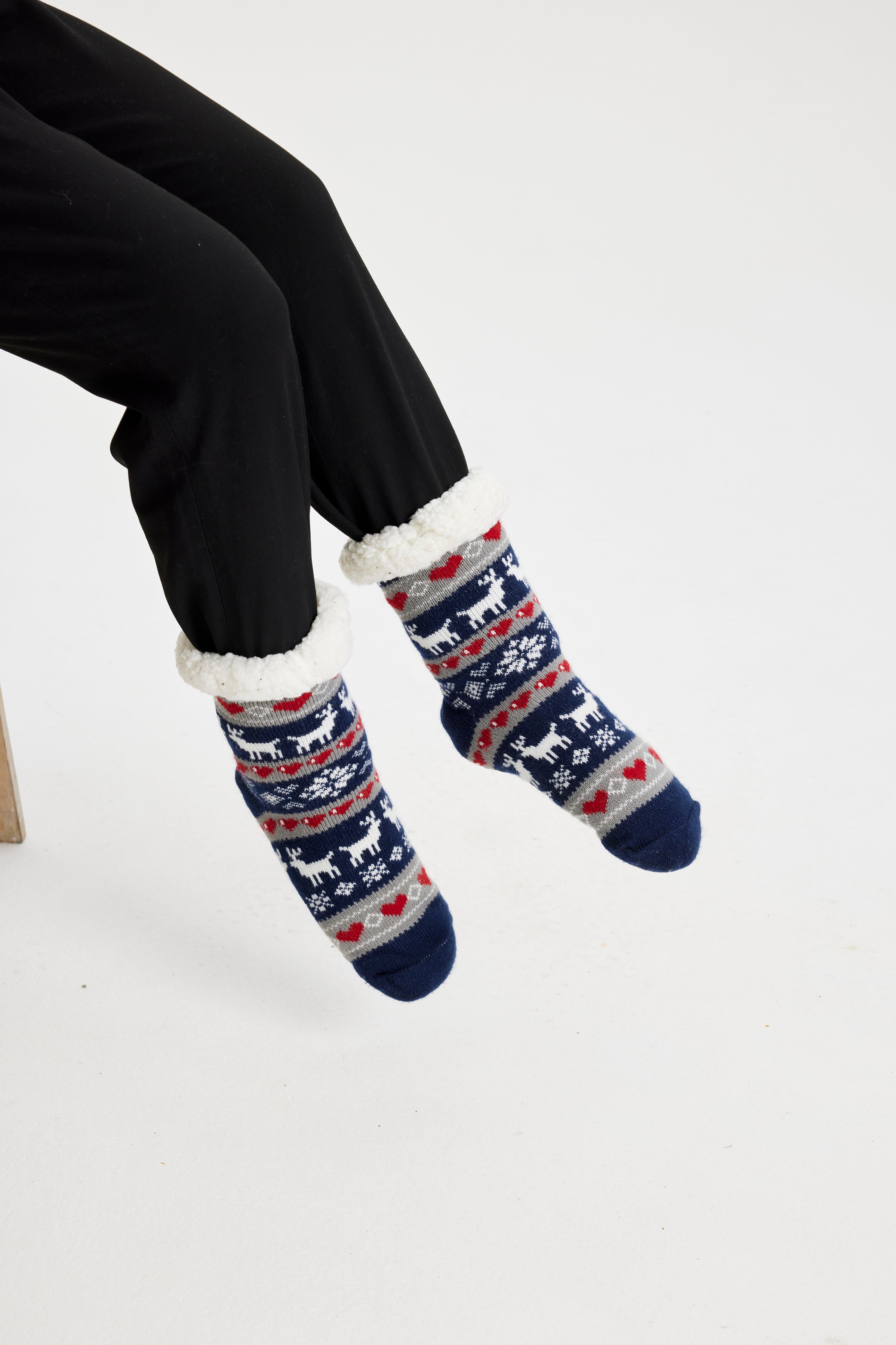 Gambe con calzini natalizi a righe blu con fantasia.