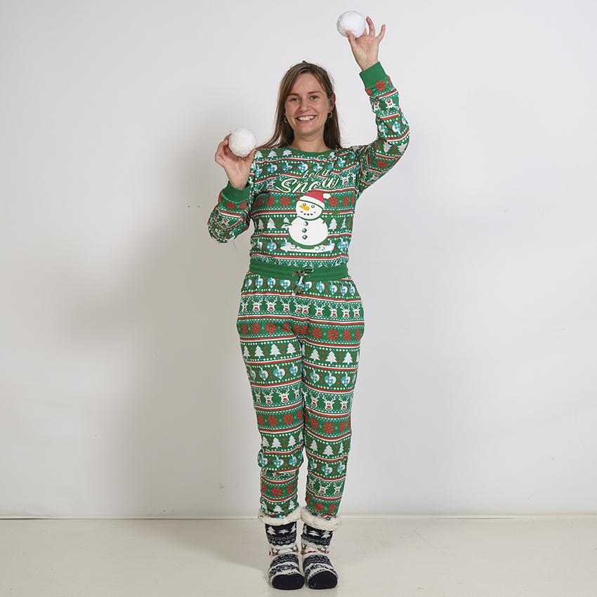 Una donna posa indossando un pigiama di Natale verde con un pupazzo di neve.
