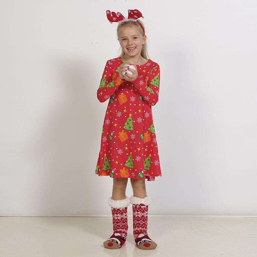 Un bambino che indossa abiti natalizi rossi con alberi di Natale.