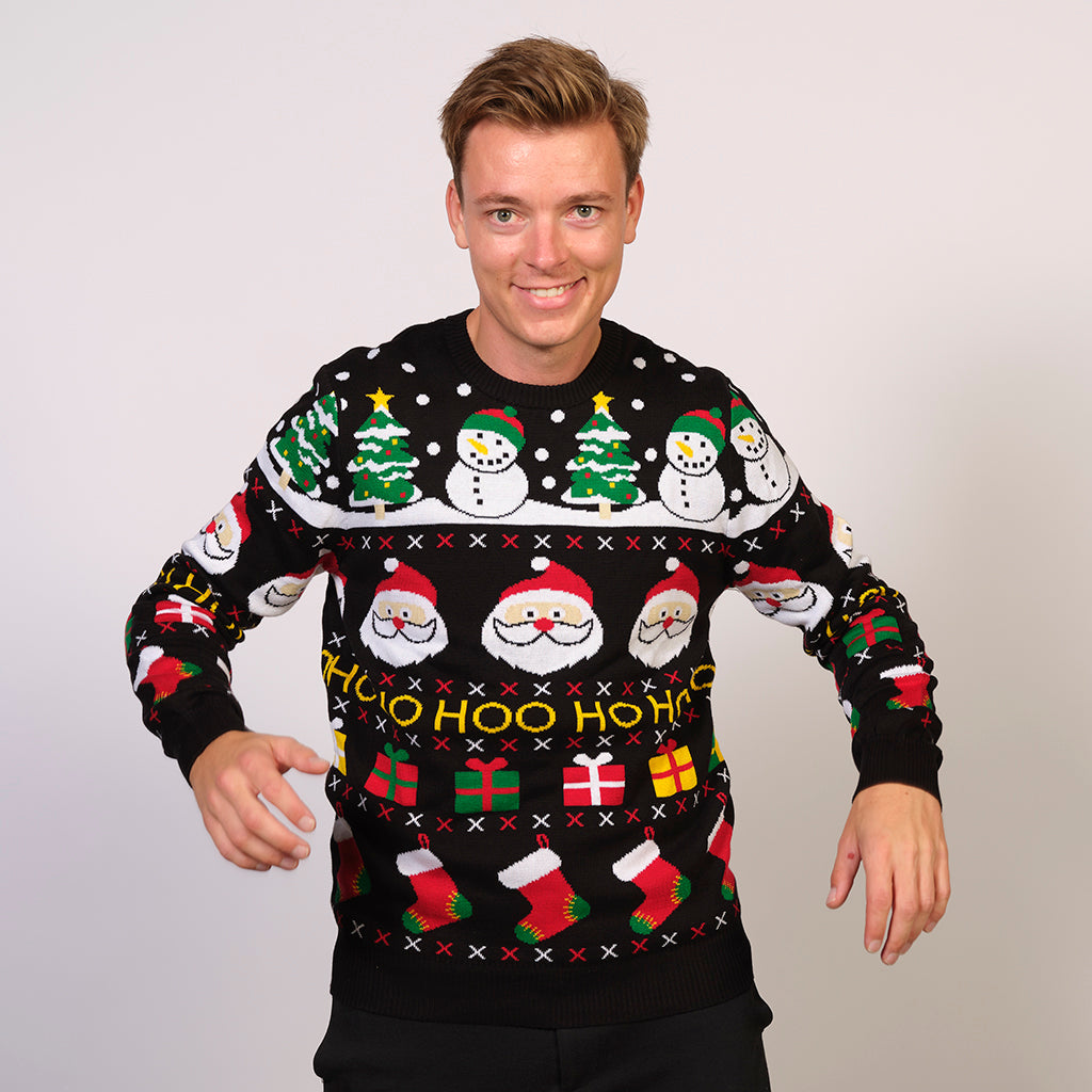 Un uomo che indossa un maglione natalizio nero con un motivo natalizio.