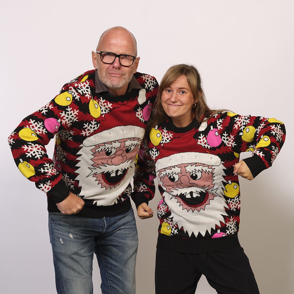 Due persone che indossano un maglione natalizio rosso e nero con un Babbo Natale sopra.