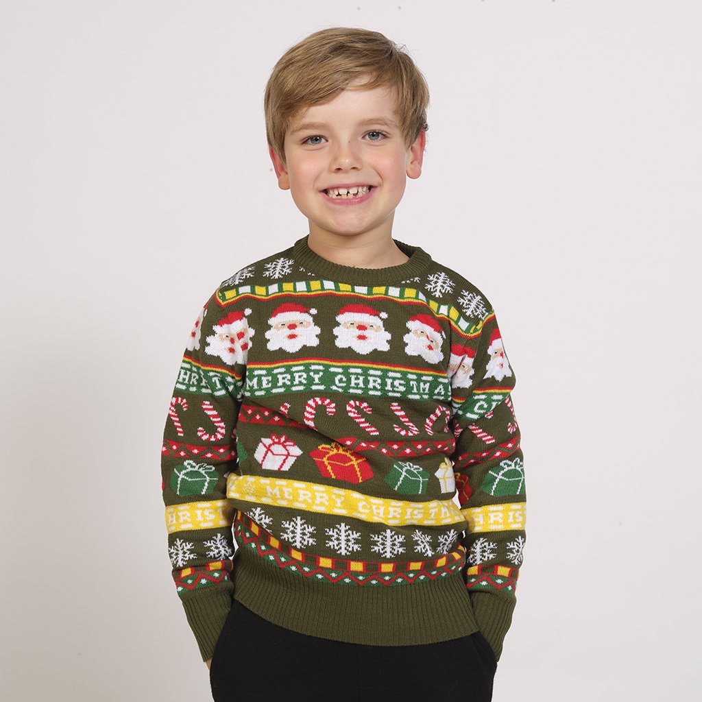 Un bambino che indossa un maglione natalizio verde con un motivo natalizio.
