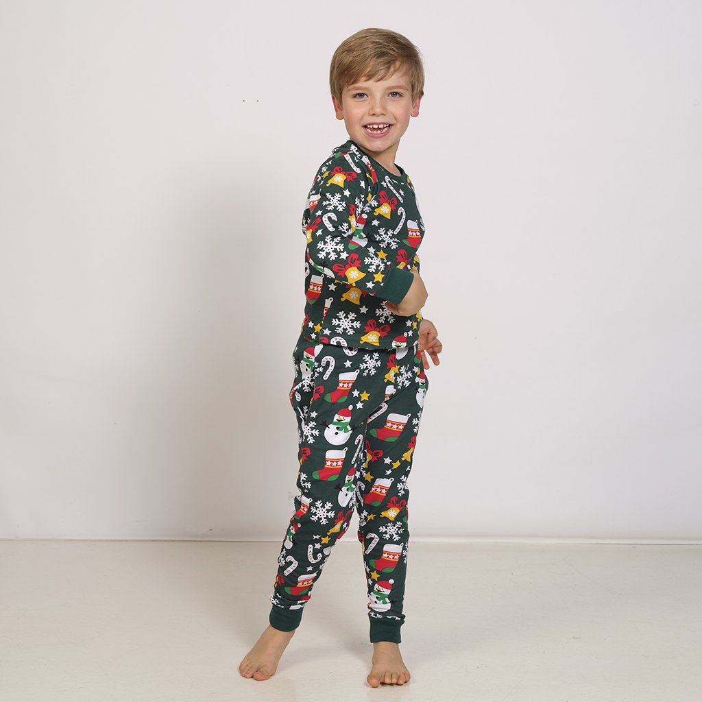 Un bambino che indossa un pigiama di Natale verde a fantasia.