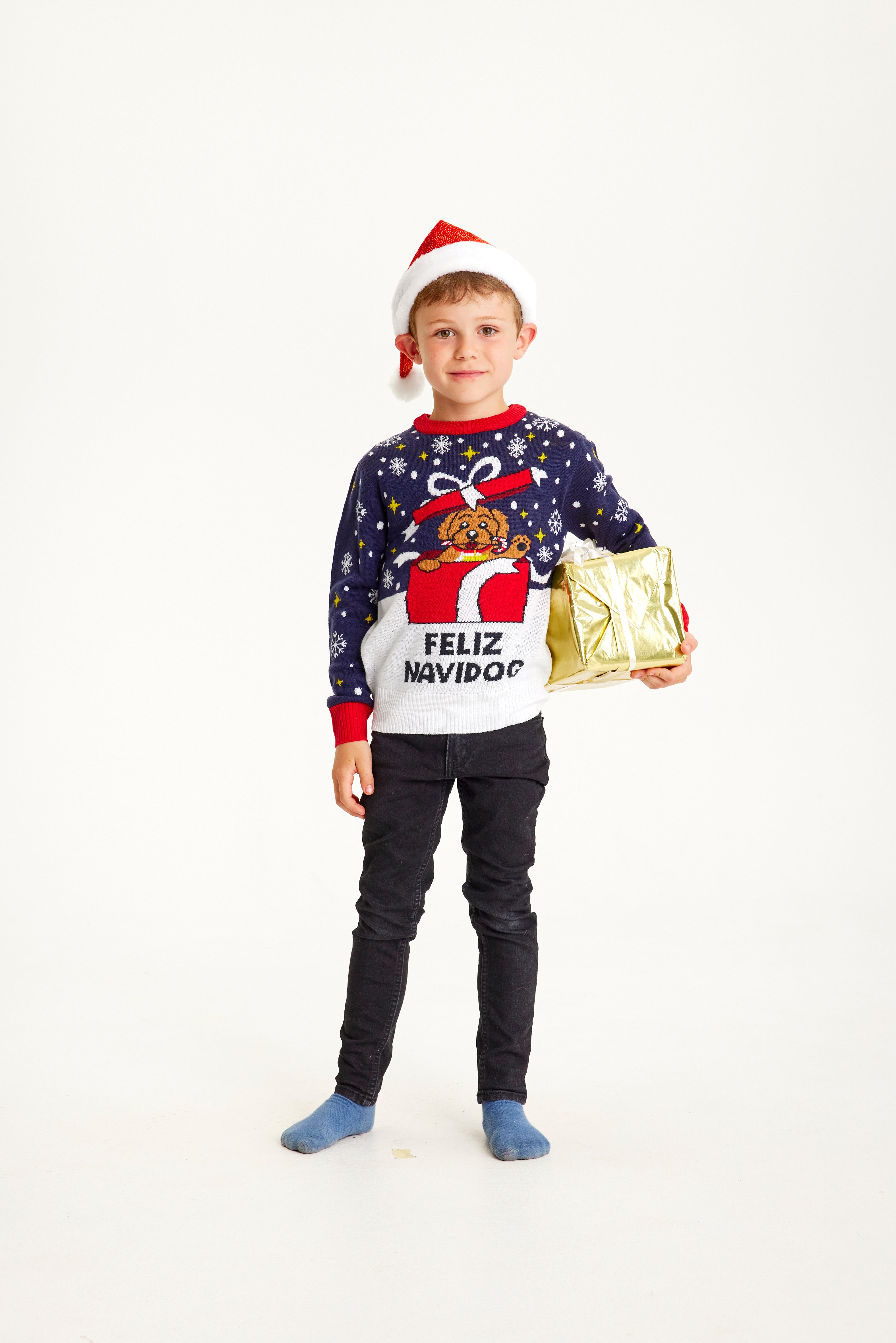 Un bambino posa indossando un maglione natalizio blu.