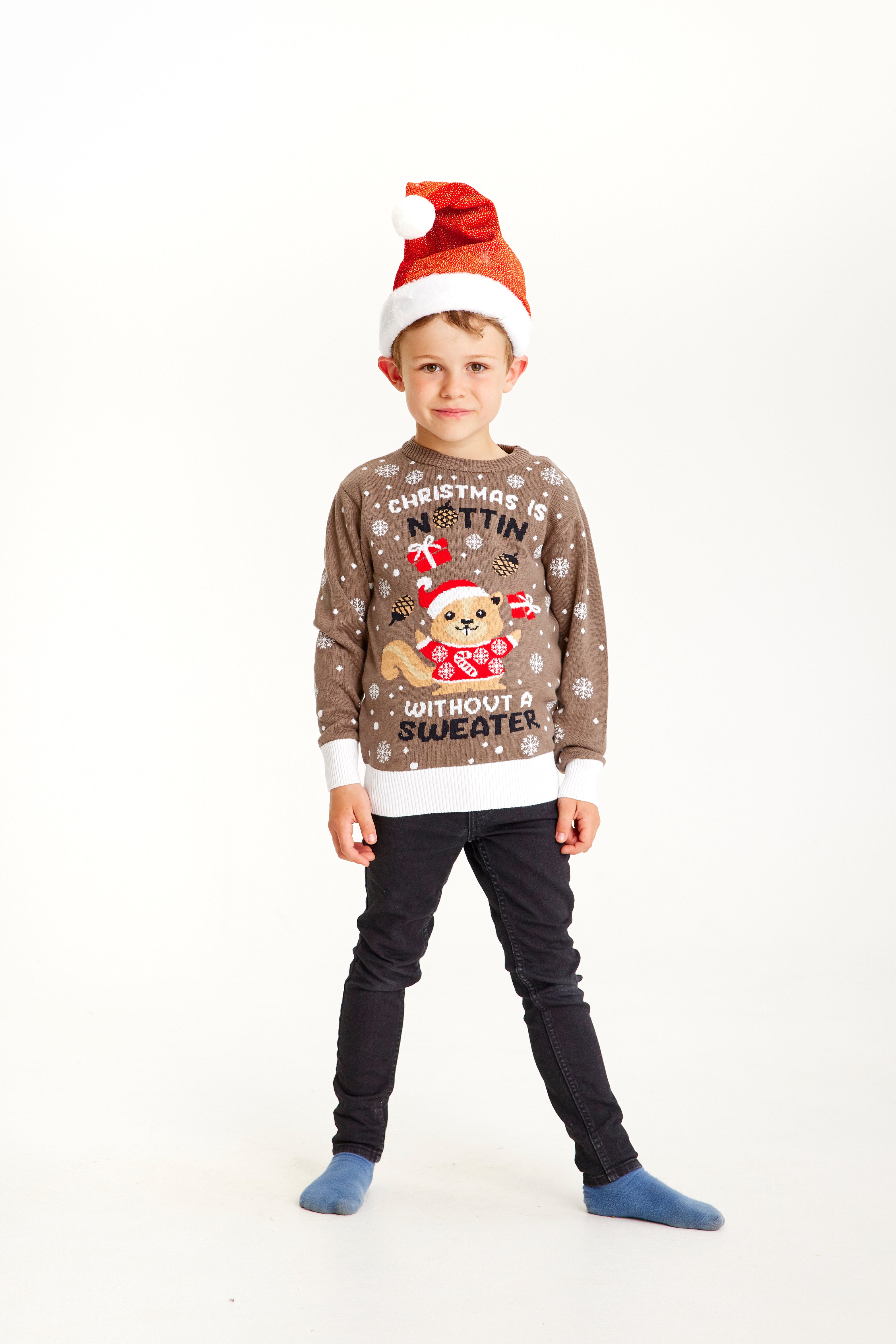 Un bambino che indossa un maglione natalizio marrone con la scritta 