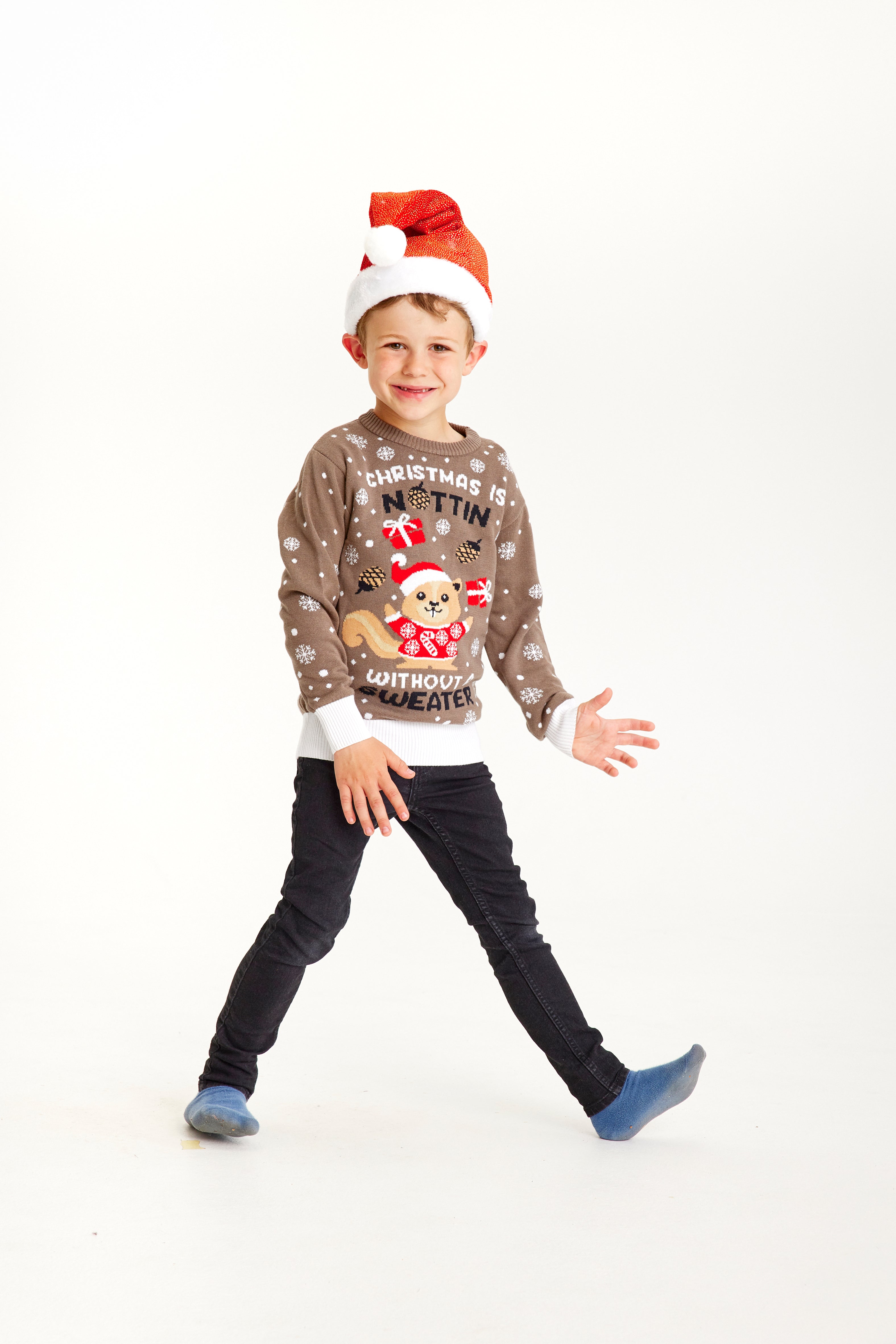 Un bambino che indossa un maglione natalizio marrone con la scritta 