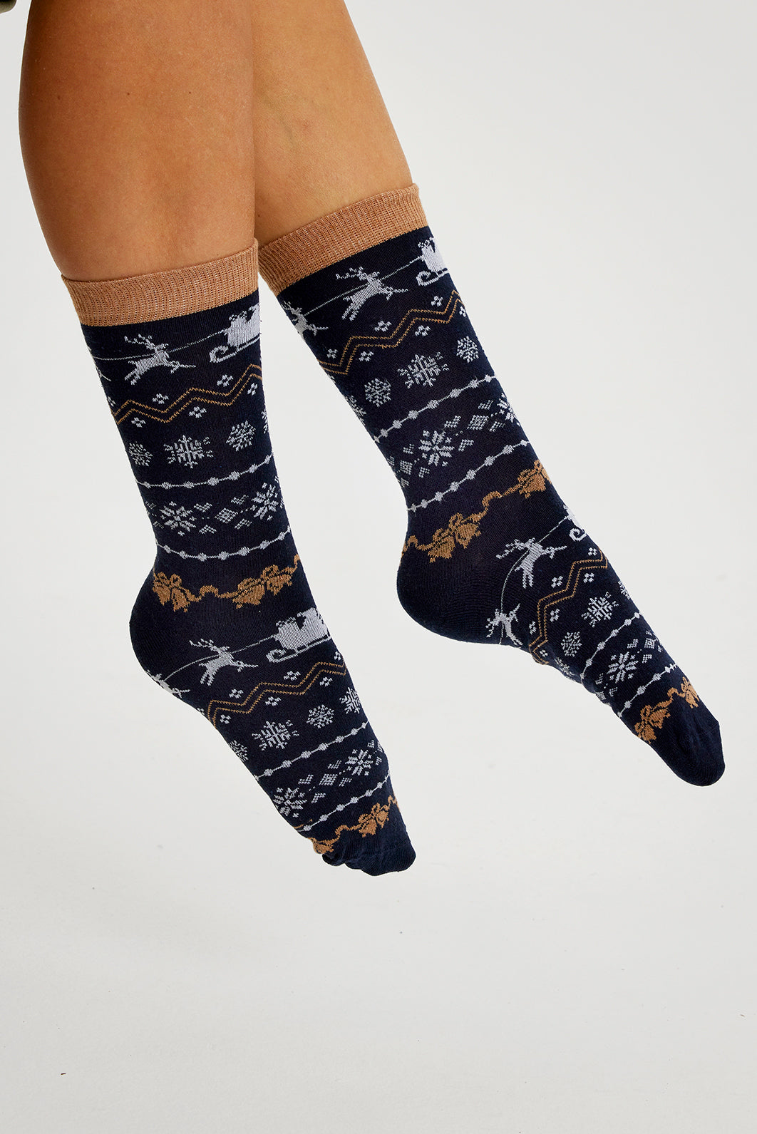 Un paio di piedi che indossano un paio di calzini natalizi neri.