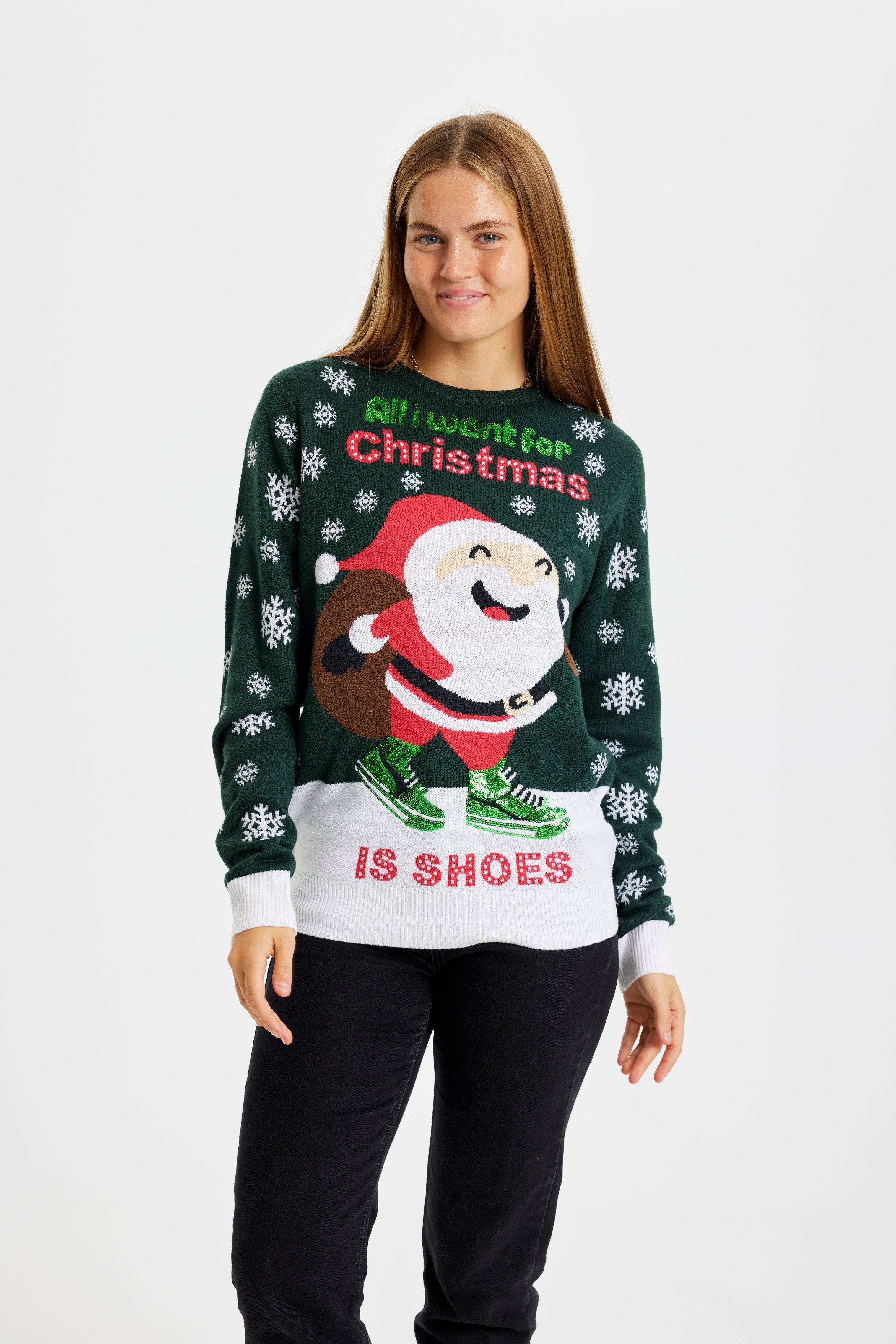 Una donna che indossa un maglione natalizio verde.