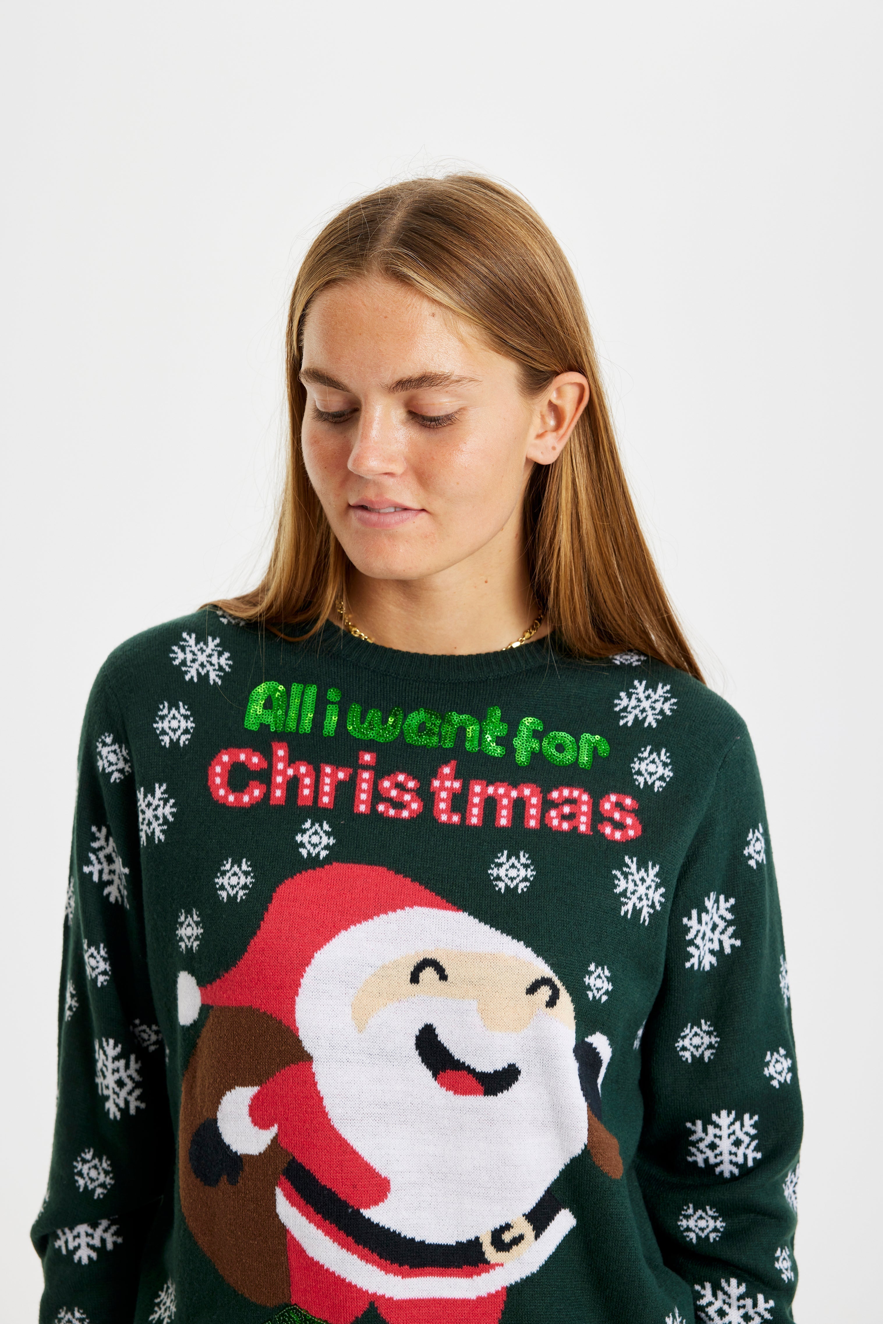 Una persona che indossa un maglione natalizio verde con la citazione 