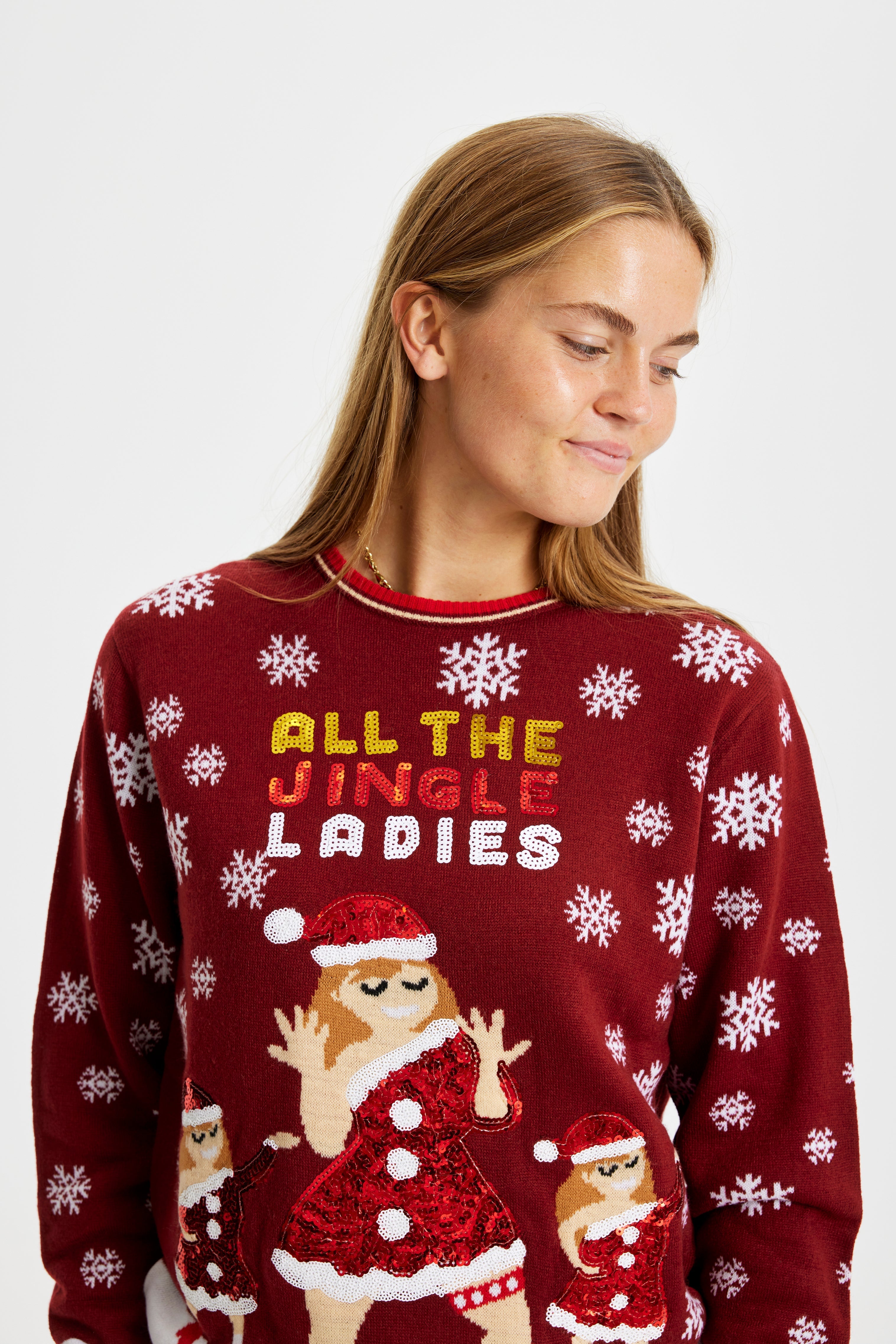 En dame fra torsoen og op, som er iført en julesweater med citatet 