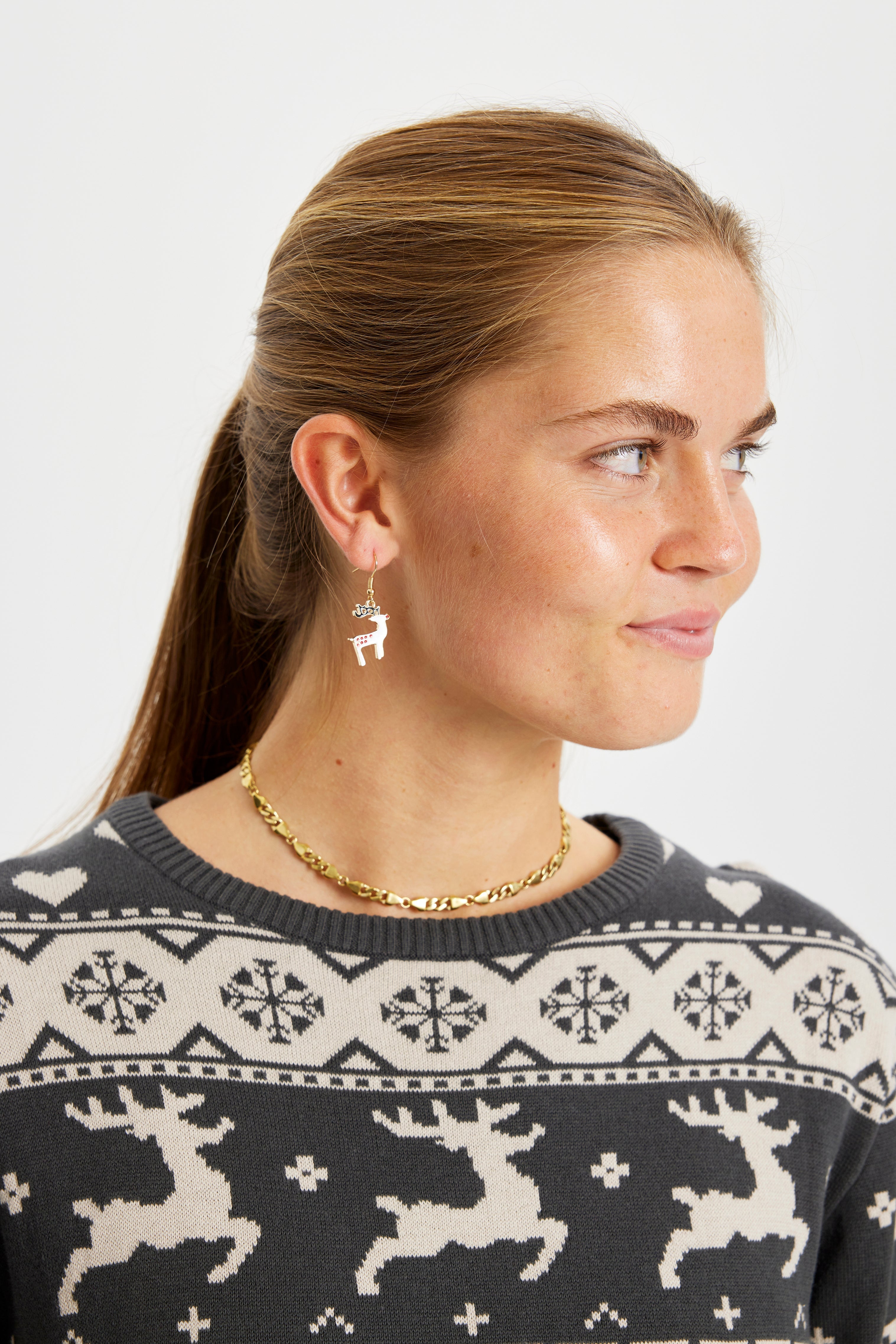 En dame med juleøreringe, der ligner rensdyr.