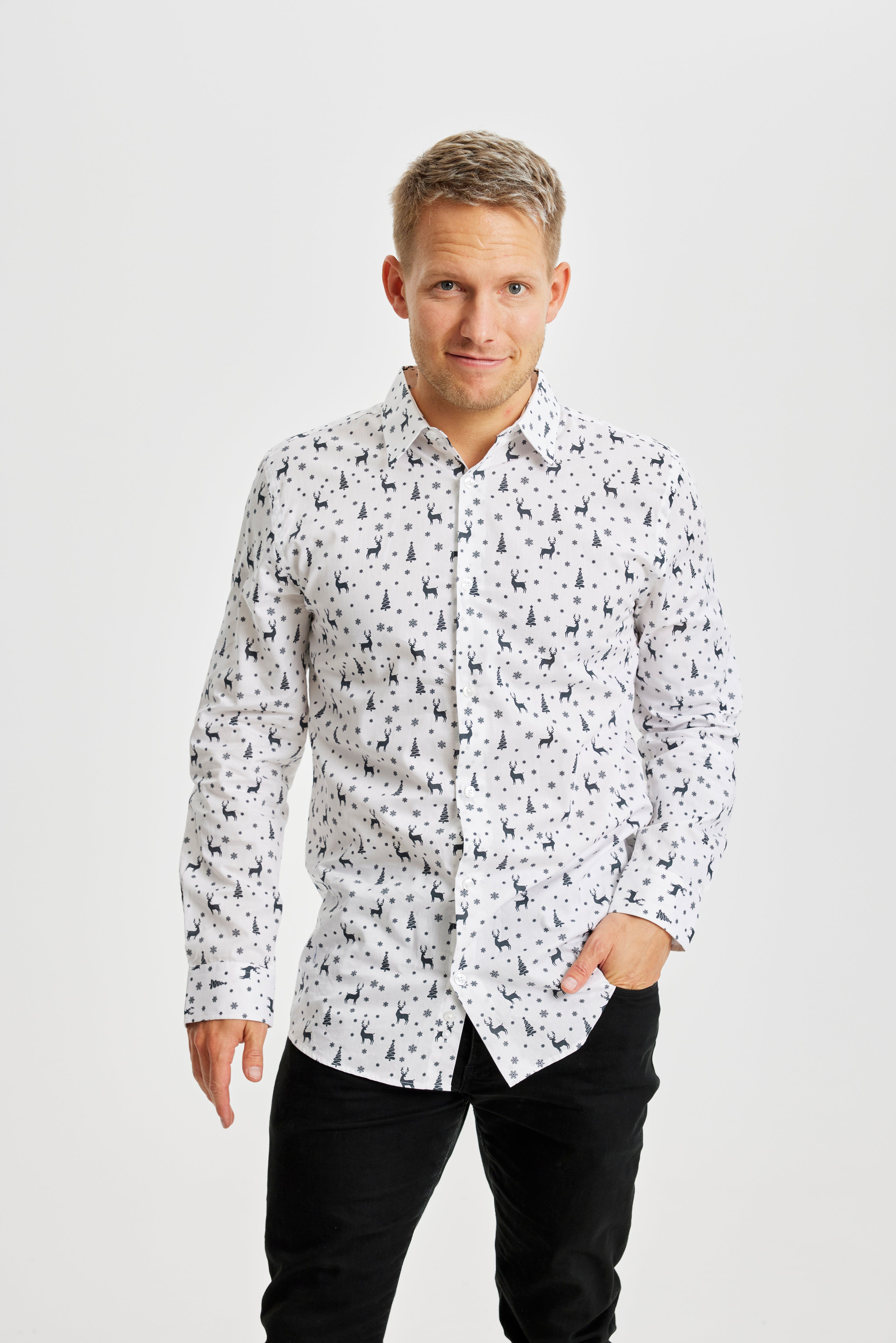 Un uomo sorridente che indossa una camicia bianca natalizia.