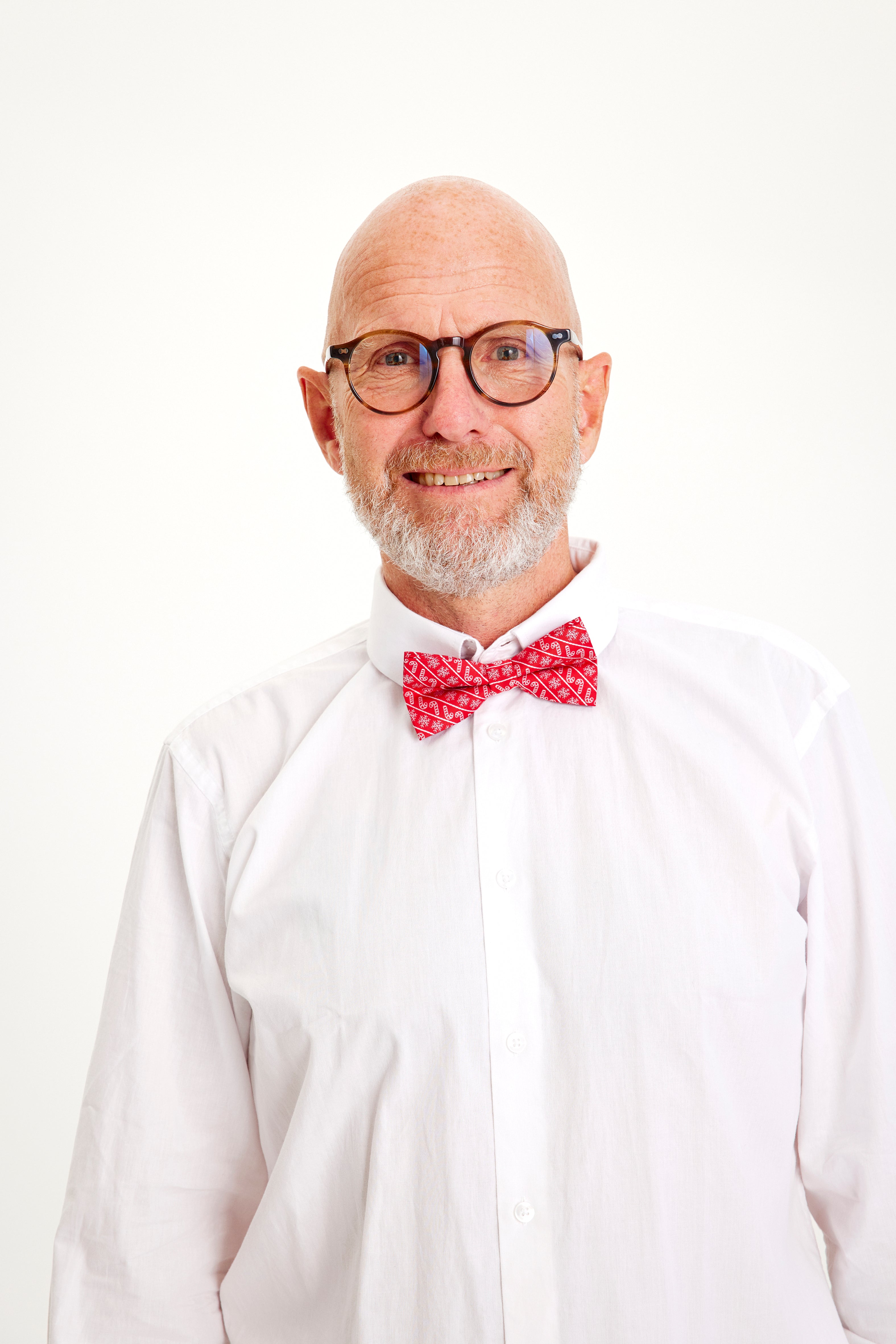 Un uomo sorridente con un papillon rosso.