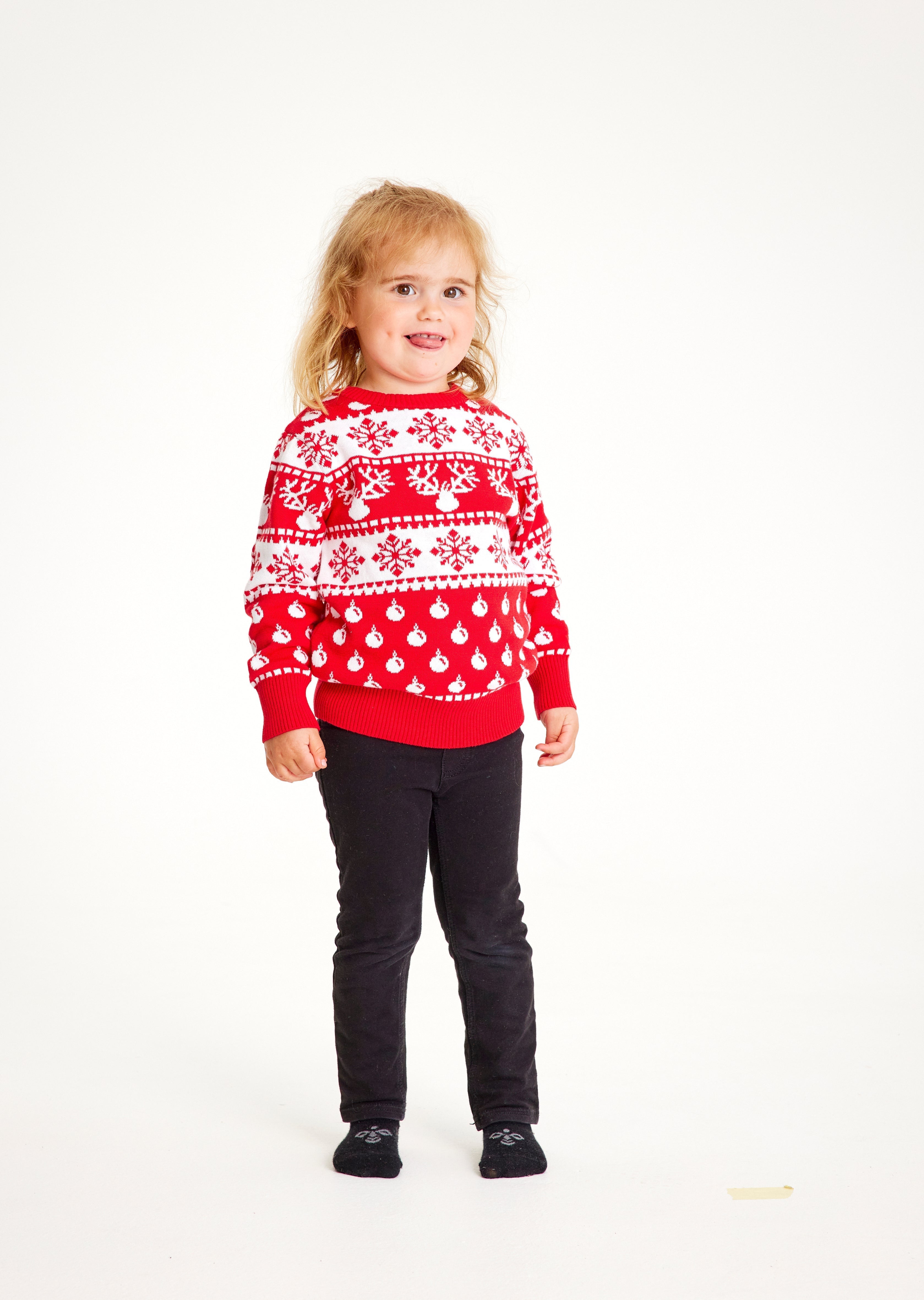 Un bambino indossa un maglione natalizio rosso.