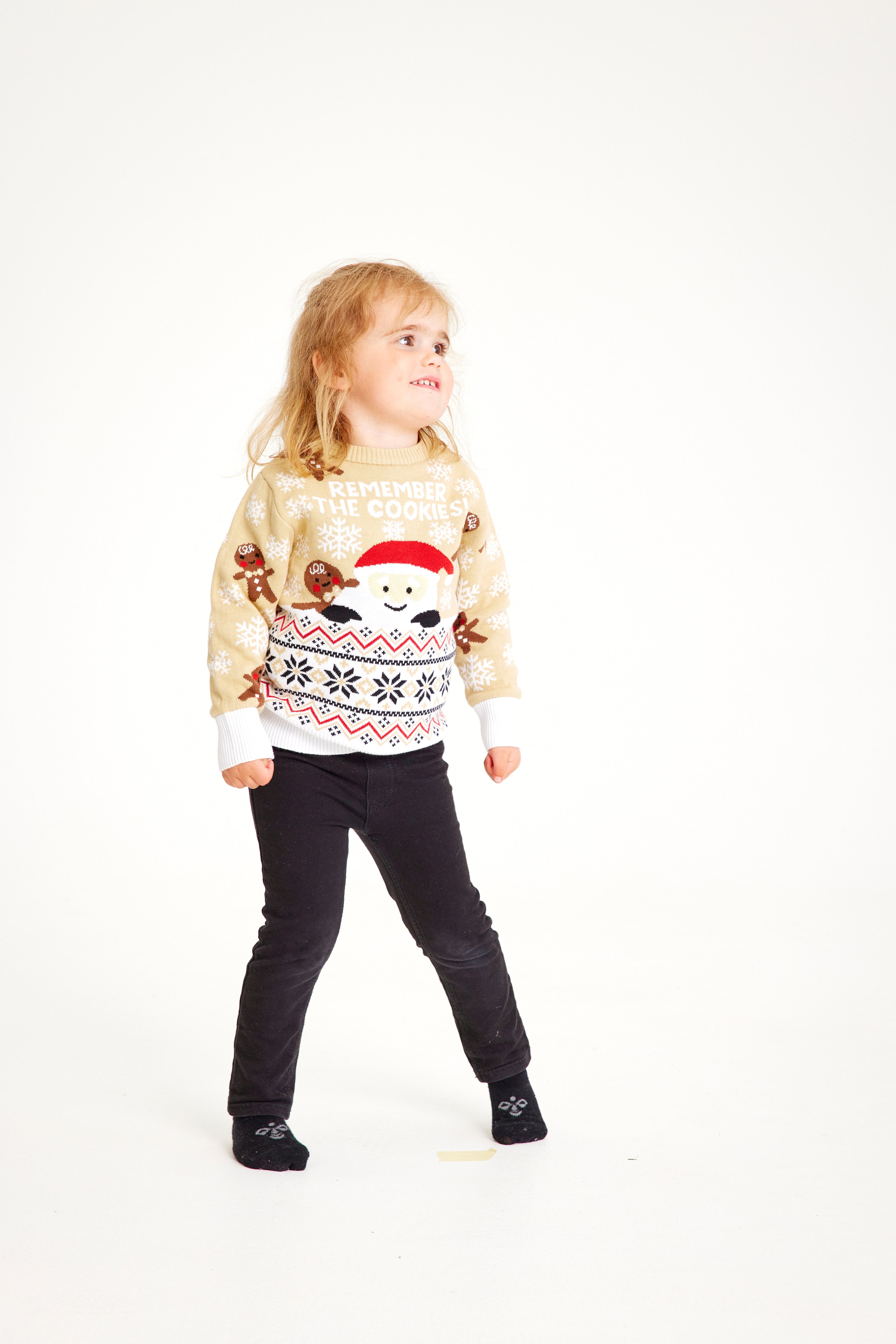 Un bambino che indossa un maglione natalizio beige con un elfo.