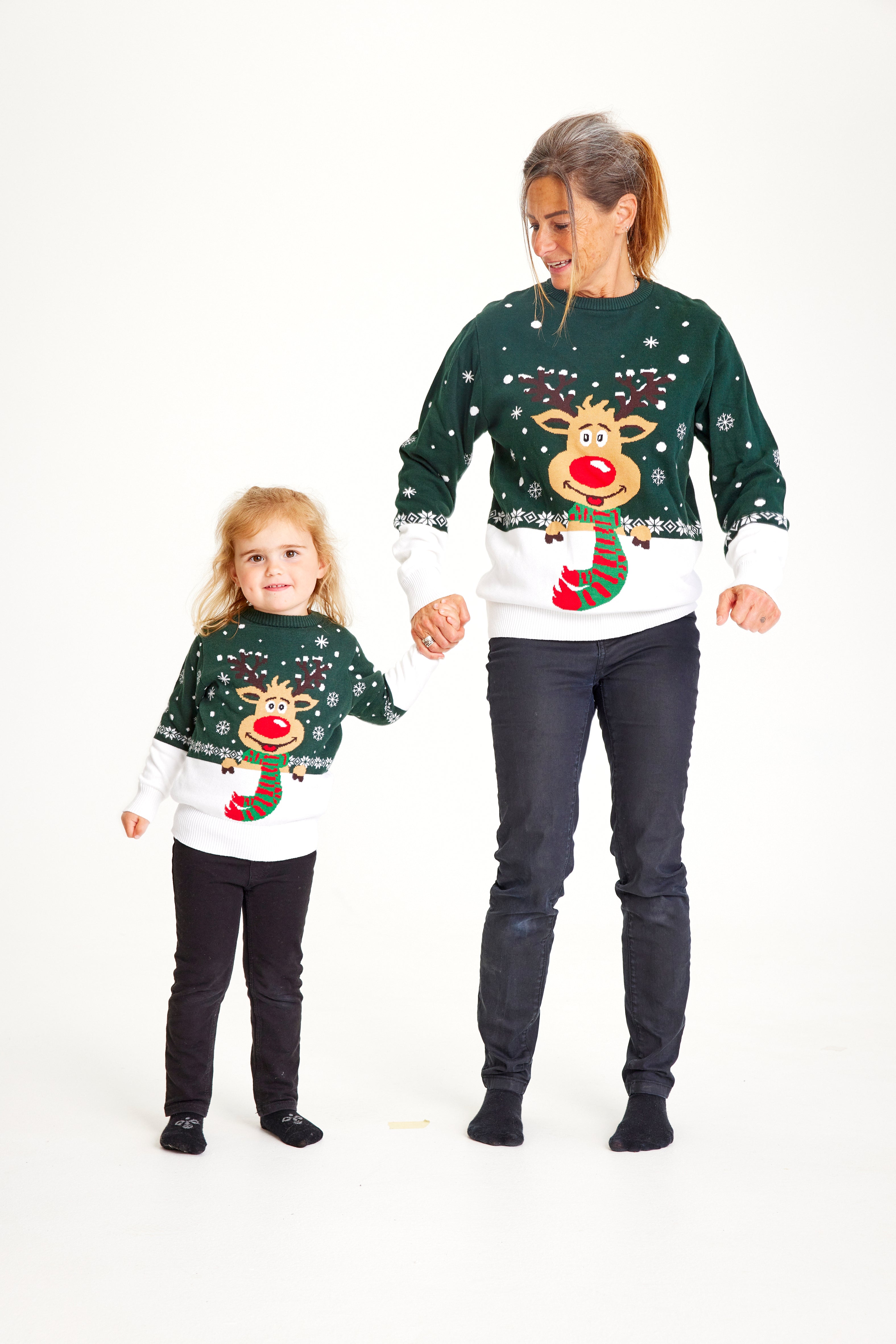 Un bambino e una donna che indossano un maglione natalizio verde e bianco con sopra Rudolph.