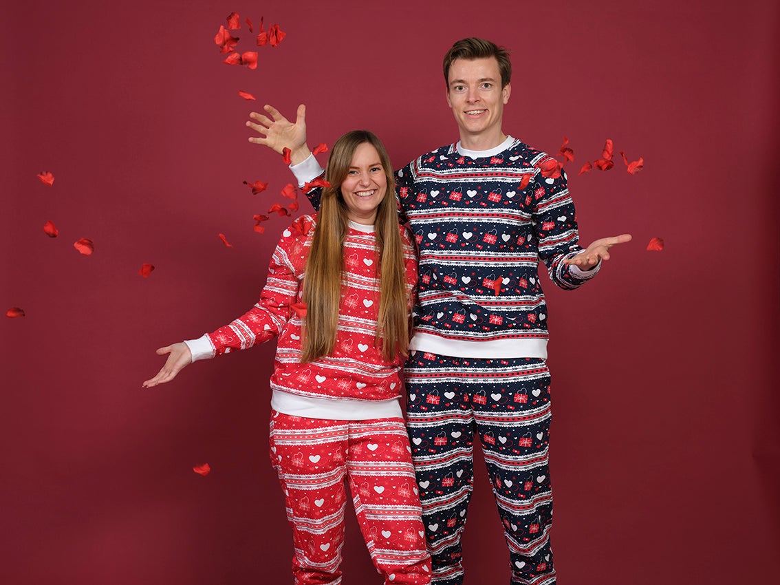 Una coppia che si abbraccia e indossa un pigiama con motivi a cuore.